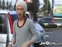Jovencitos japoneses besándose apasionadamente en la parte trasera del coche