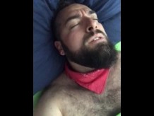 Un gran oso barbudo y peludo se masturba frotando la sábana sobre su polla dura y húmeda. hermosa agonía