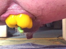 Primer plano anal gape con un pimiento amarillo