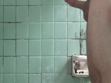 Jugando con una polla en la sucia ducha del albergue